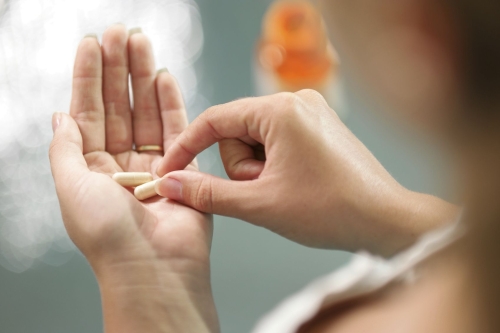 A woman in taking a tablet